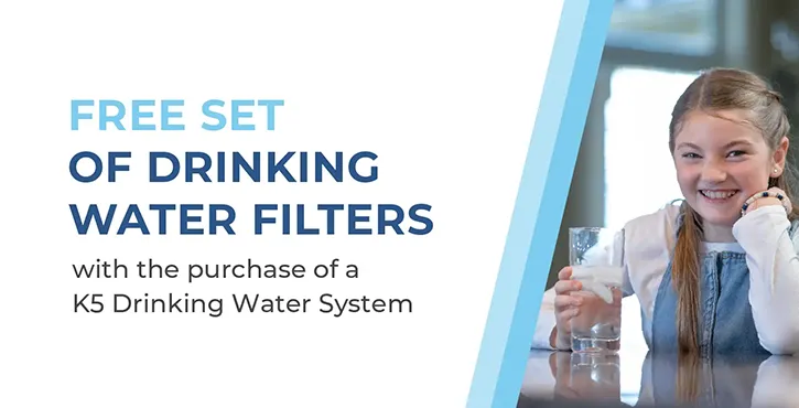 Text reads: FREE SET OF DRINKING WATER FILTERS with the purchase of a K5 Drinking Water System. A smiling girl holds a glass of water on the right side of the image.